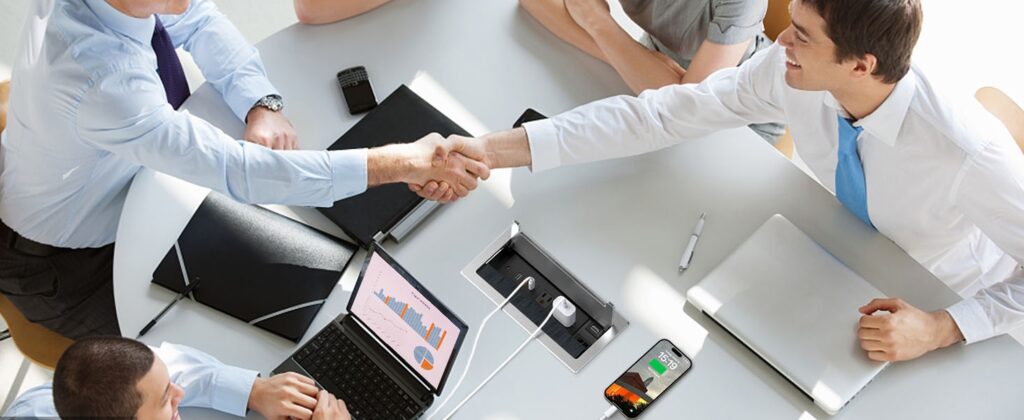 Commercial-grade pop-up desktop socket installed in hotel room desk showing robust aluminum housing