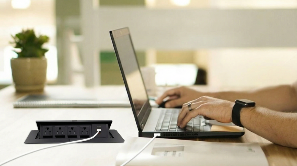 Pop-up socket rising from a clean wooden desk demonstrating clutter-free workspace design