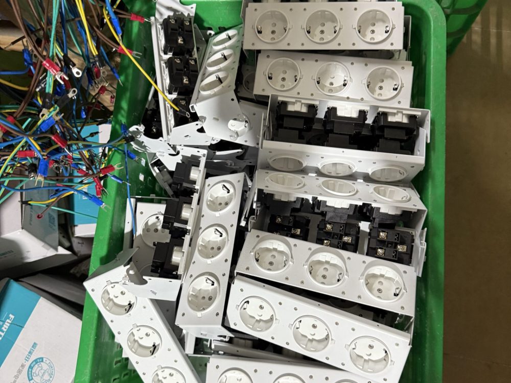 Workers assembling pop-up desktop sockets on professional production line at Moonian manufacturing facility